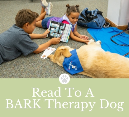 Children reading to therapy dog